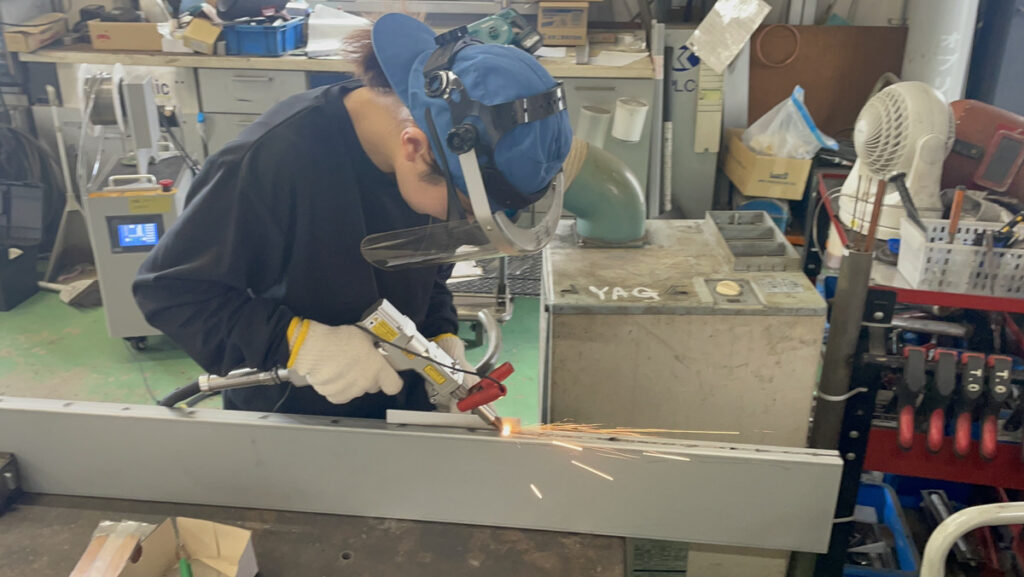 ケーアイ工業様の工場で金属フレームを溶接している様子