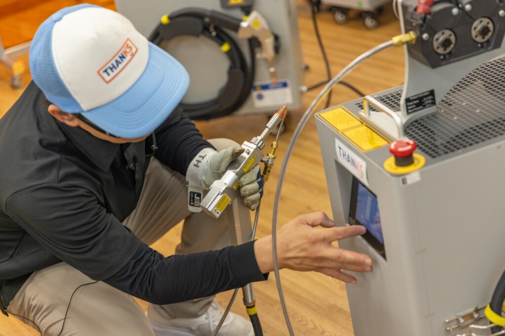 納品時に溶接機の設定を行うスタッフ